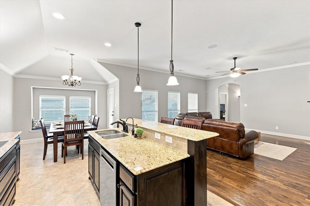 Kitchen island with a double basin sink and stainless steel dishwasher, vaulted ceiling, recessed lighting, wood-finish flooring, and a ceiling fan