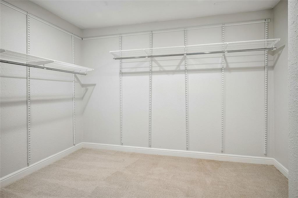 Main bedroom closet, 8x10 Walk-in  featuring adjustable wire shelving, integrated hanging rods, plush carpet flooring, and white baseboard trim