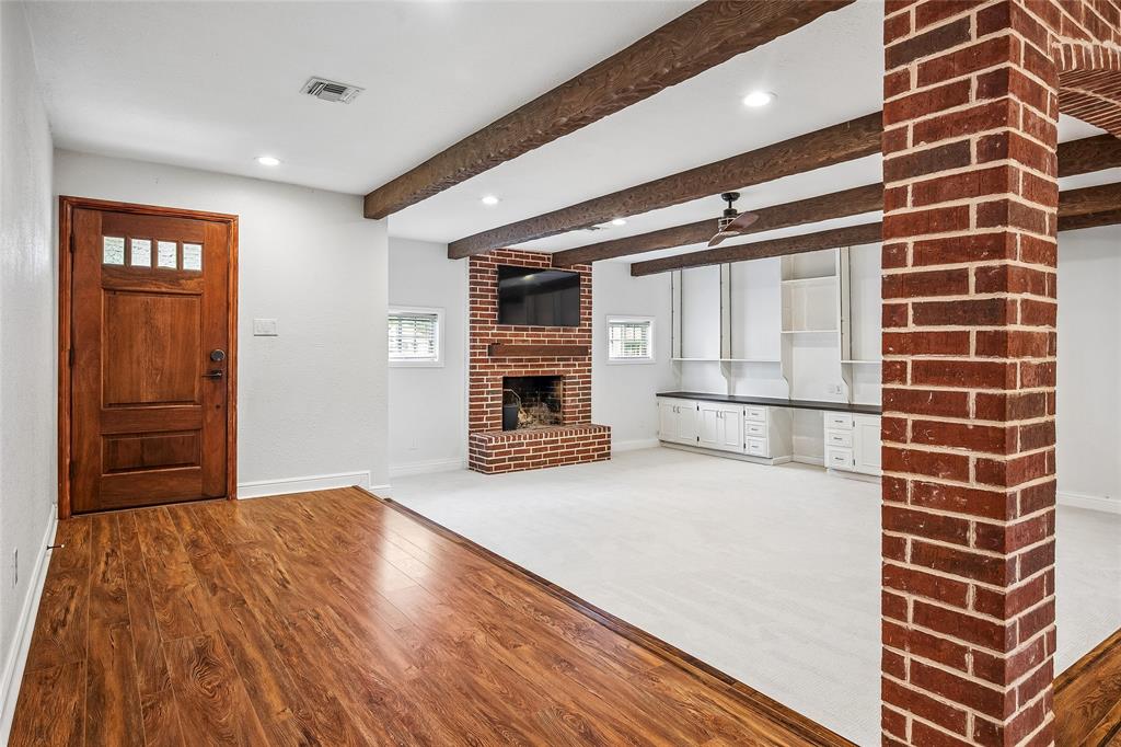 BVIRTUAL STAGING edroom featuring a rustic wood barn door, hardwood flooring, ceiling fan, and a window with horizontal blinds