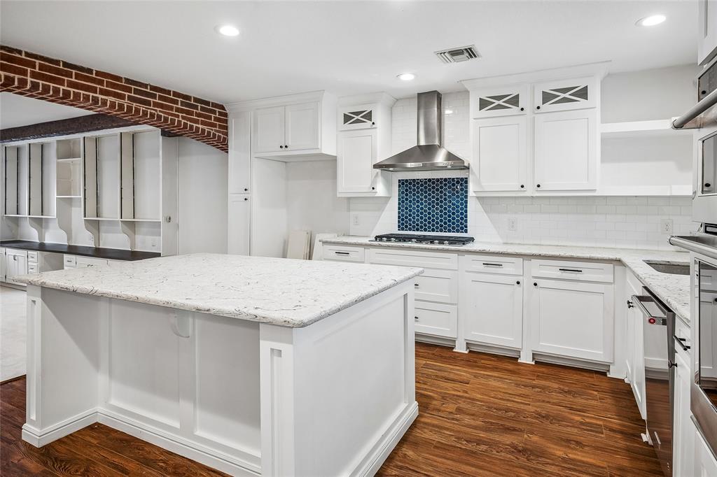Open concept living space featuring a carpeted area with built-in white cabinetry and a dark wood-finish countertop