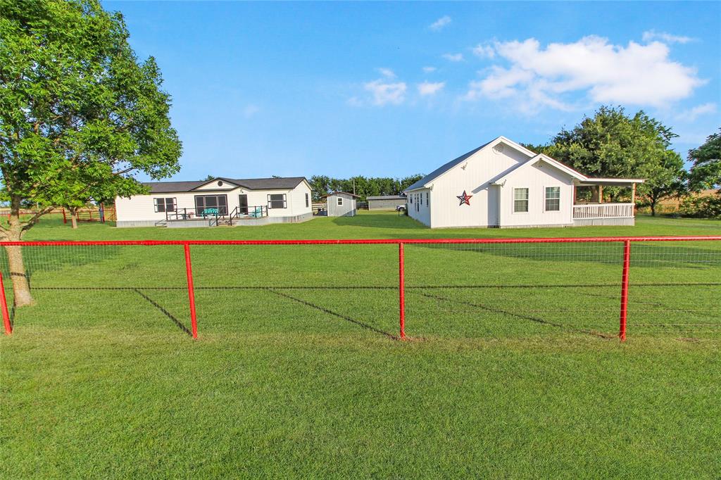 Expansive green lawn with a red-framed wire fence Expansive green lawn with a red-framed wire fence