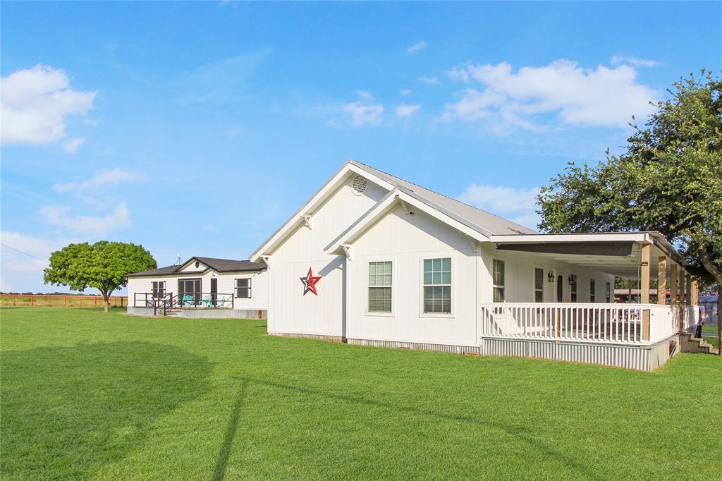 White-sided exterior with a metal roof and an expansive lawn White-sided exterior with a metal roof and an expansive lawn