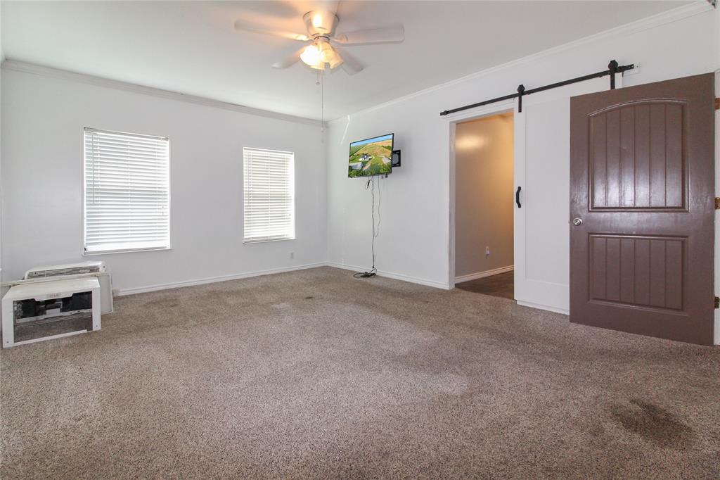 1936  HOUSE Spacious room featuring neutral carpeting, white walls, and a ceiling fan