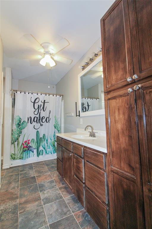 1936  HOUSE Bathroom vanity with wood-finish cabinetry, white countertop, and integrated sink