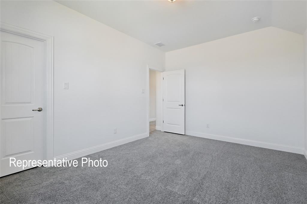 Spacious room featuring light gray carpeting and bright white walls