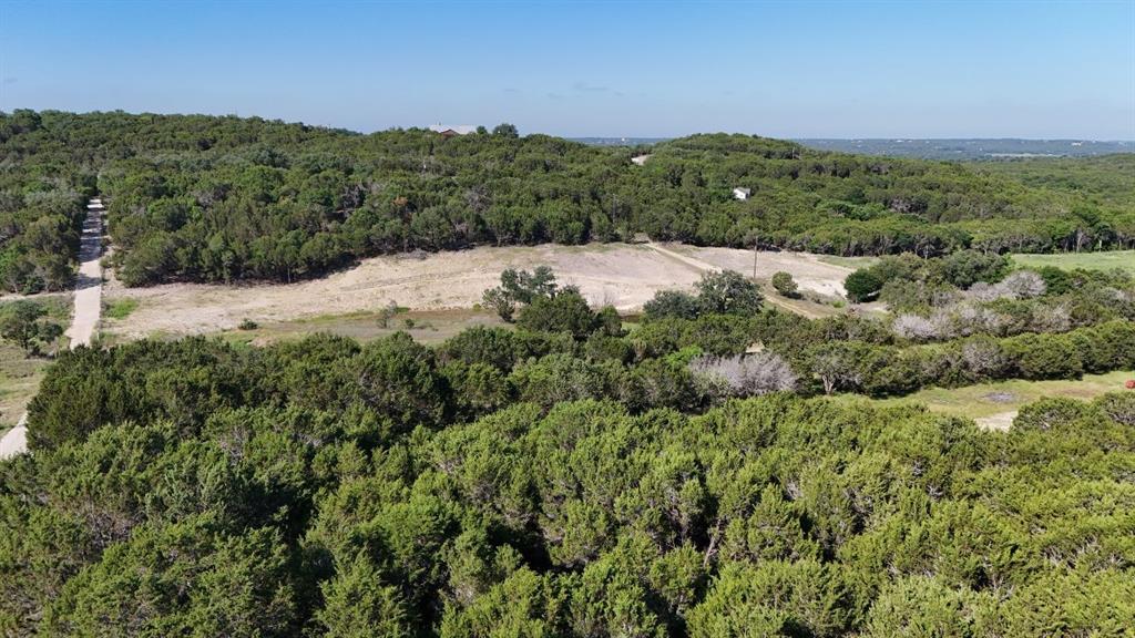 Expansive property featuring dense tree coverage, open clearings, and a defined track
