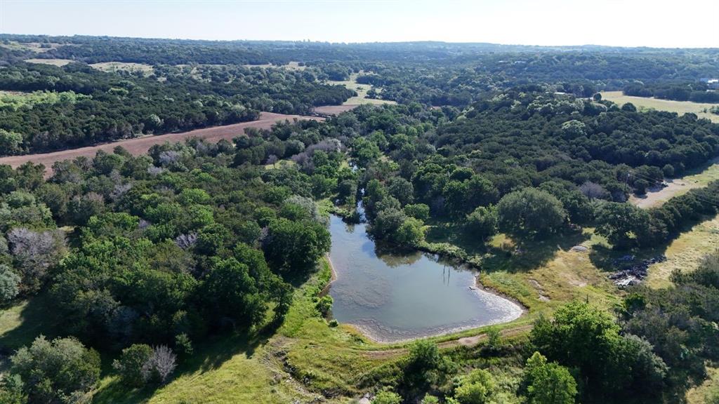 Natural water feature with surrounding wooded areas and open fields