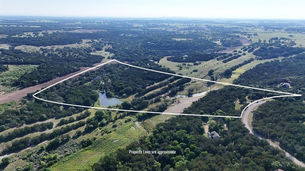 Expansive acreage featuring abundant mature trees, a natural pond, and varied topography