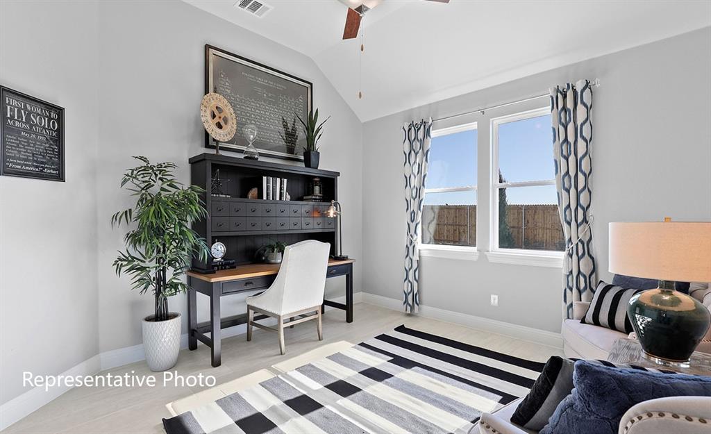 Room featuring vaulted ceilings with a ceiling fan, light-toned wood-finish flooring, and bright windows with white trim