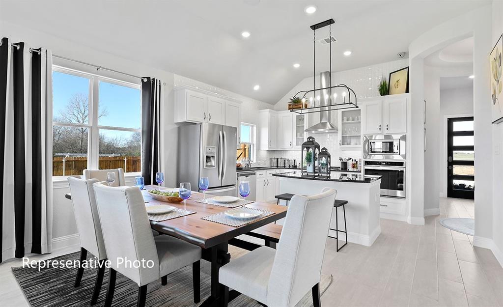 Open-concept living space featuring a vaulted ceiling and light wood-finish flooring