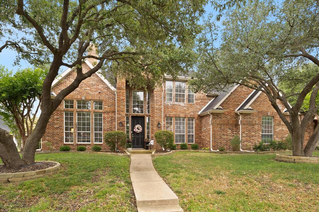 Mature trees and lush landscaping add to this home's gorgeous curb appeal!