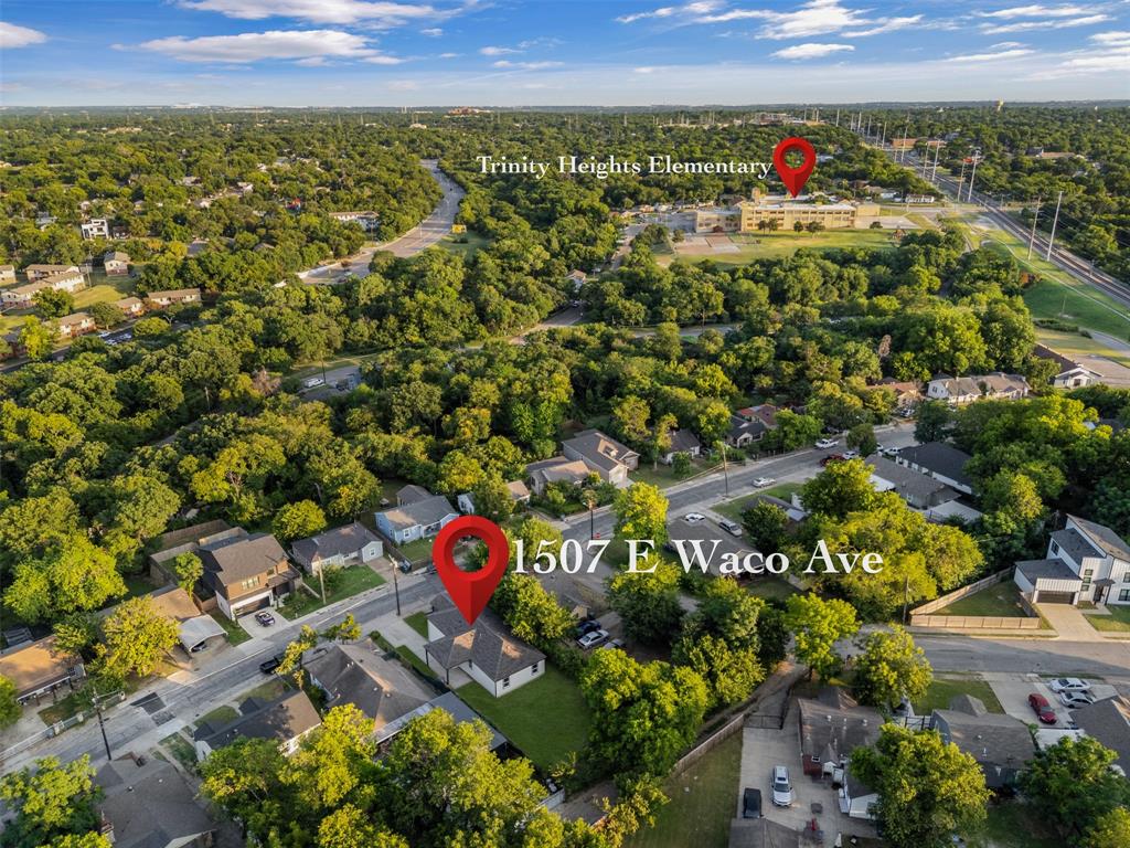 Aerial perspective showcasing a residential street with properties featuring green lawns and mature trees