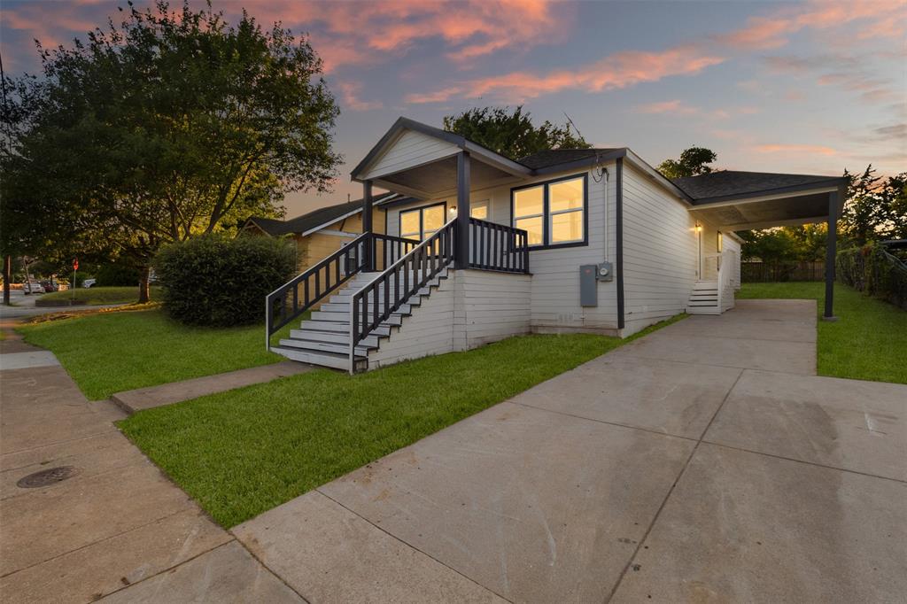 Single-story residence featuring a covered front porch with steps and dark railings Single-story residence featuring a covered front porch with steps and dark railings