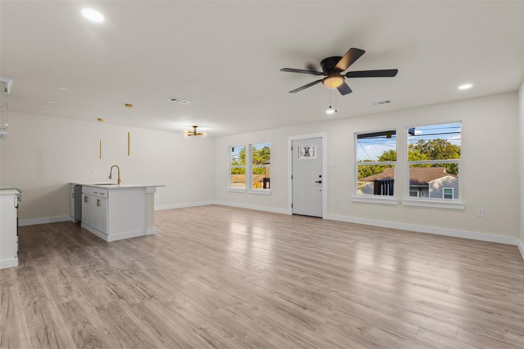 Spacious open-concept interior featuring light wood-finish flooring throughout