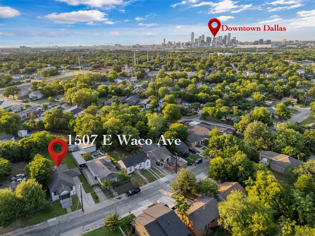 Aerial view showcasing a residential neighborhood with abundant mature trees and proximity to the Downtown Dallas skyline
