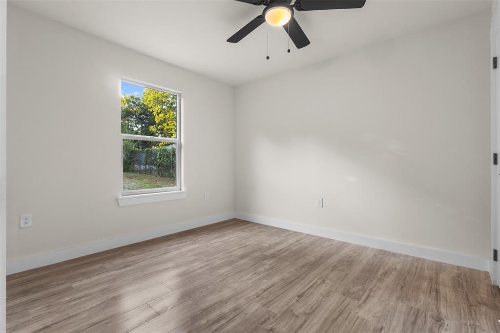 Interior room featuring wood-finish flooring and a ceiling fan with integrated lighting