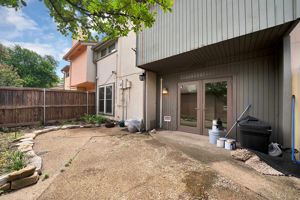 Concrete patio area featuring a stone border and wood privacy fencing