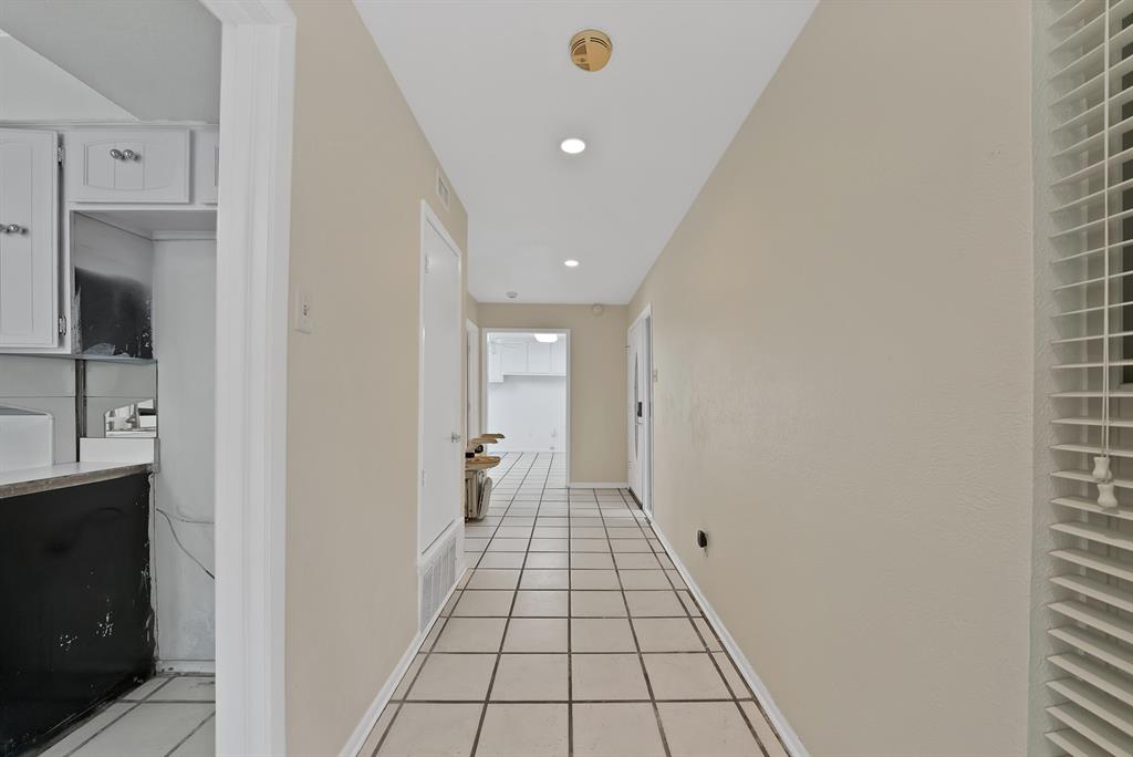 Hallway with square tile flooring, recessed lighting, and neutral wall paint