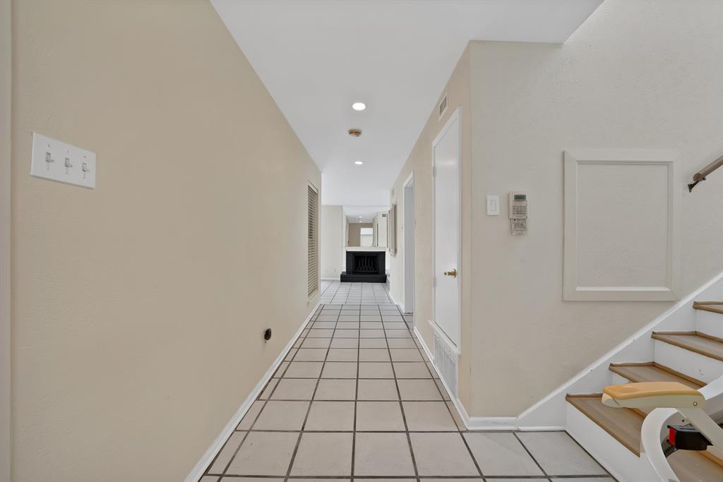 Hallway with square tile flooring, recessed lighting, and light neutral wall finishes