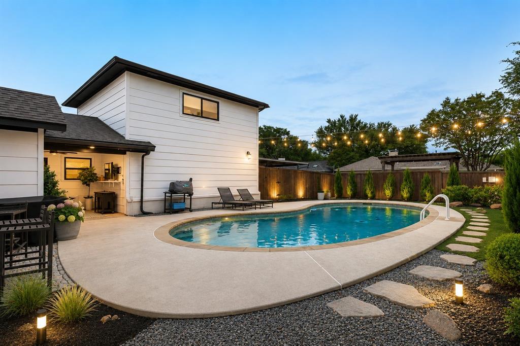 Inviting backyard featuring an in-ground swimming pool with surrounding concrete decking