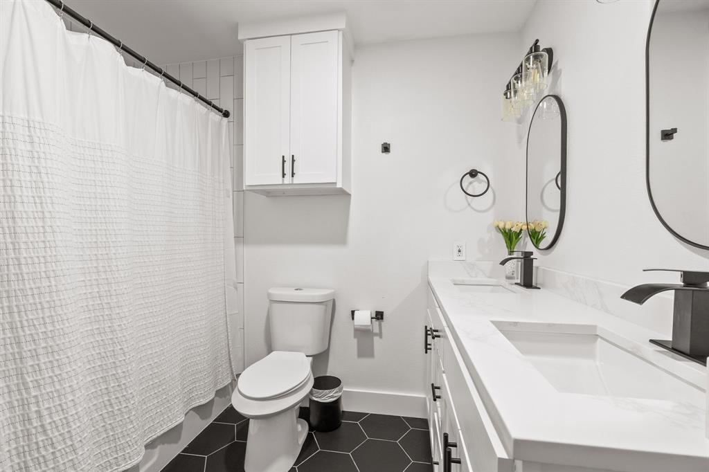 Bathroom featuring a dual vanity with undermount sinks, white countertops, and matte black fixtures