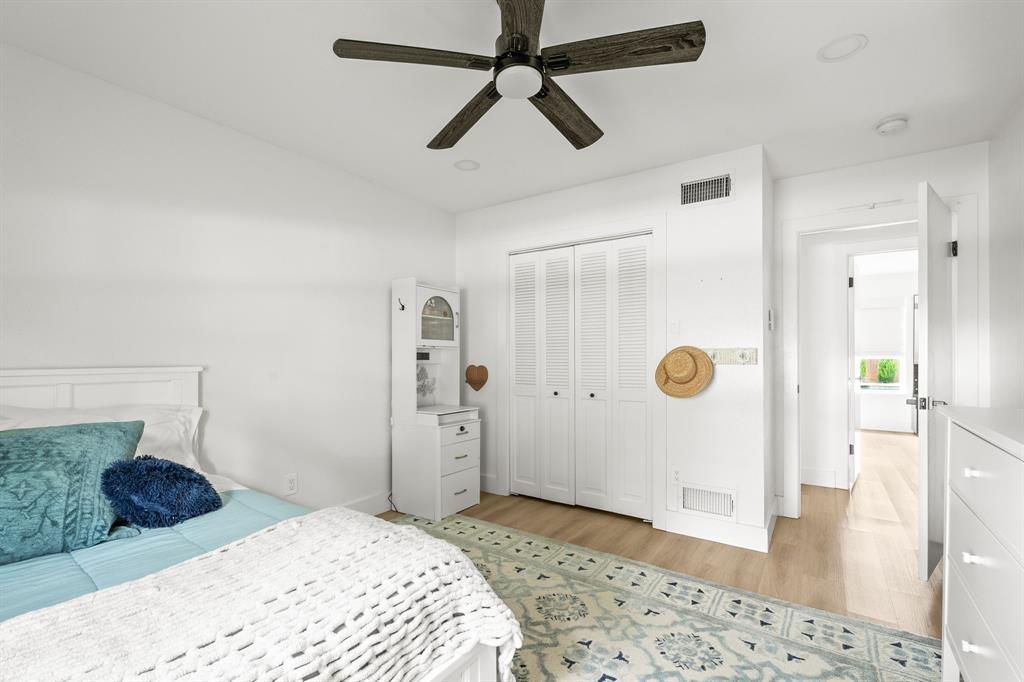Light-toned wood-finish flooring complements white walls and recessed lighting