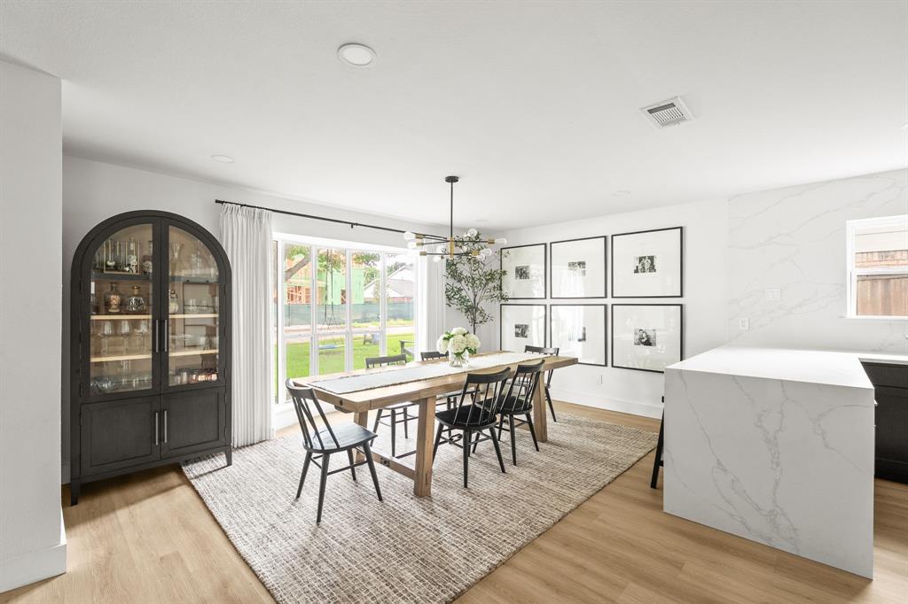 Open-concept room featuring wood-finish flooring, recessed lighting, and a large window overlooking the backyard Open-concept room featuring wood-finish flooring, recessed lighting, and a large window overlooking the backyard