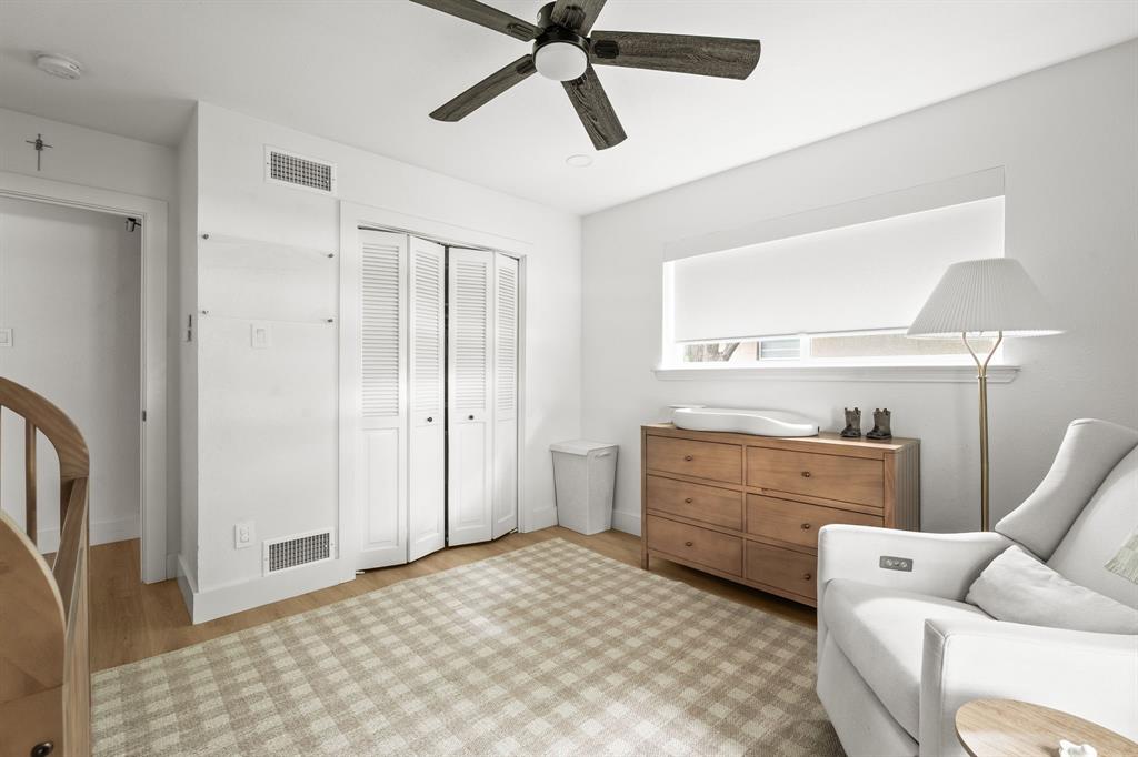 Bright room featuring wood-finish flooring and a ceiling fan with integrated lighting