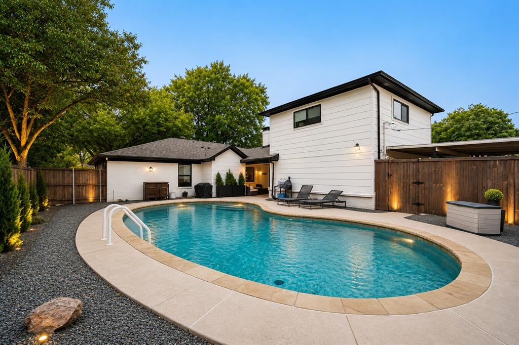 Oval-shaped swimming pool with a concrete surround and integrated steps