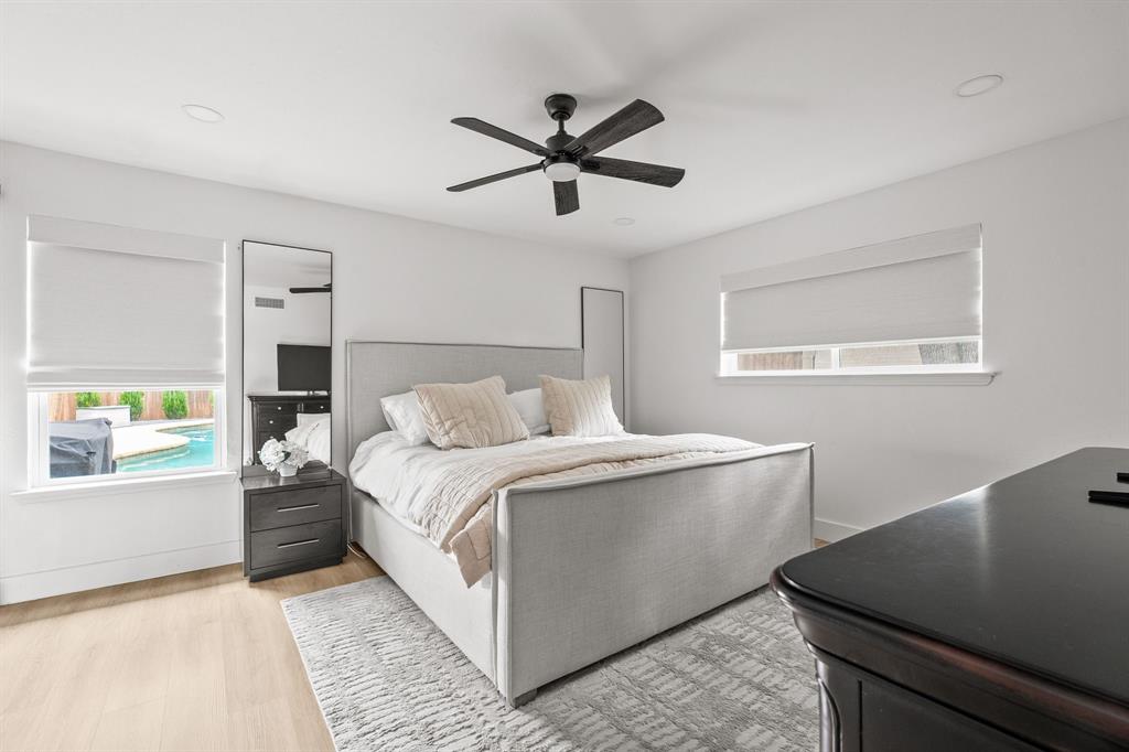 Bedroom featuring light wood-finish flooring, recessed lighting, and a dark-toned ceiling fan