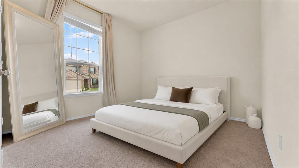Carpeted room featuring a large window with grid panes, neutral wall paint, and white baseboards