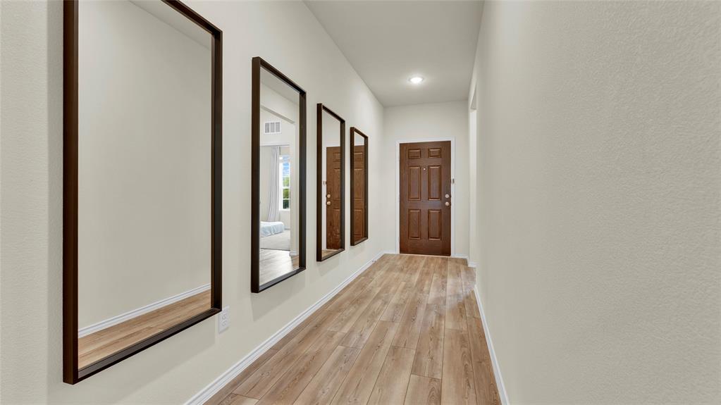 Entryway featuring wood-finish flooring, light neutral wall tones, and a paneled entry door