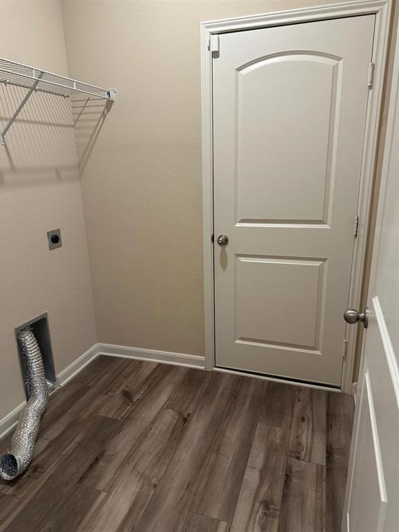 Utility space featuring wood-finish flooring, light tan walls, and white trim