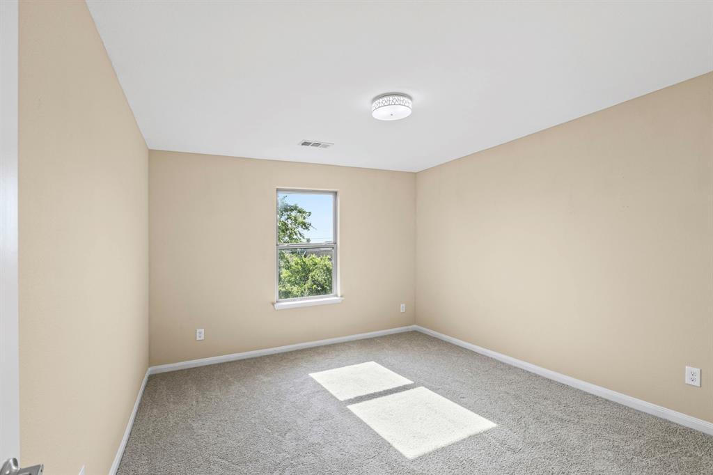 Bedroom featuring neutral wall paint, gray carpet flooring, a single window, white trim, and a flush-mount ceiling light fixture