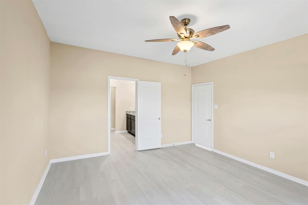 Spacious room featuring vaulted ceilings, light wood-finish flooring, and neutral wall tones
