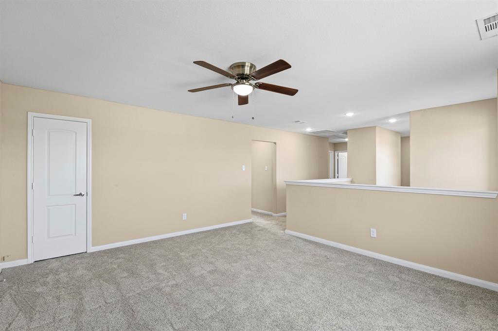 Carpeted room featuring a ceiling fan with integrated lighting, recessed lighting, and a half-wall partition