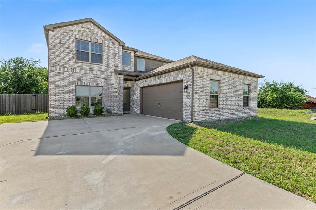 Two-story residence featuring light brick masonry, a two-car garage with a dark brown door, and a concrete driveway Two-story residence featuring light brick masonry, a two-car garage with a dark brown door, and a concrete driveway