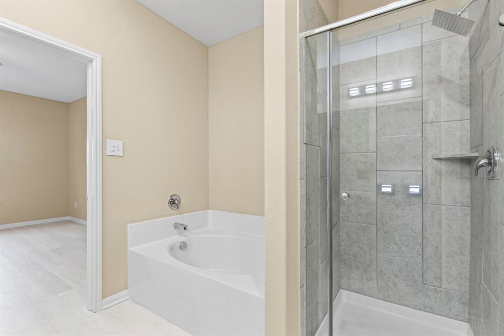 Bathroom featuring a tiled walk-in shower with a glass enclosure, a built-in shower shelf, and a square rainfall showerhead