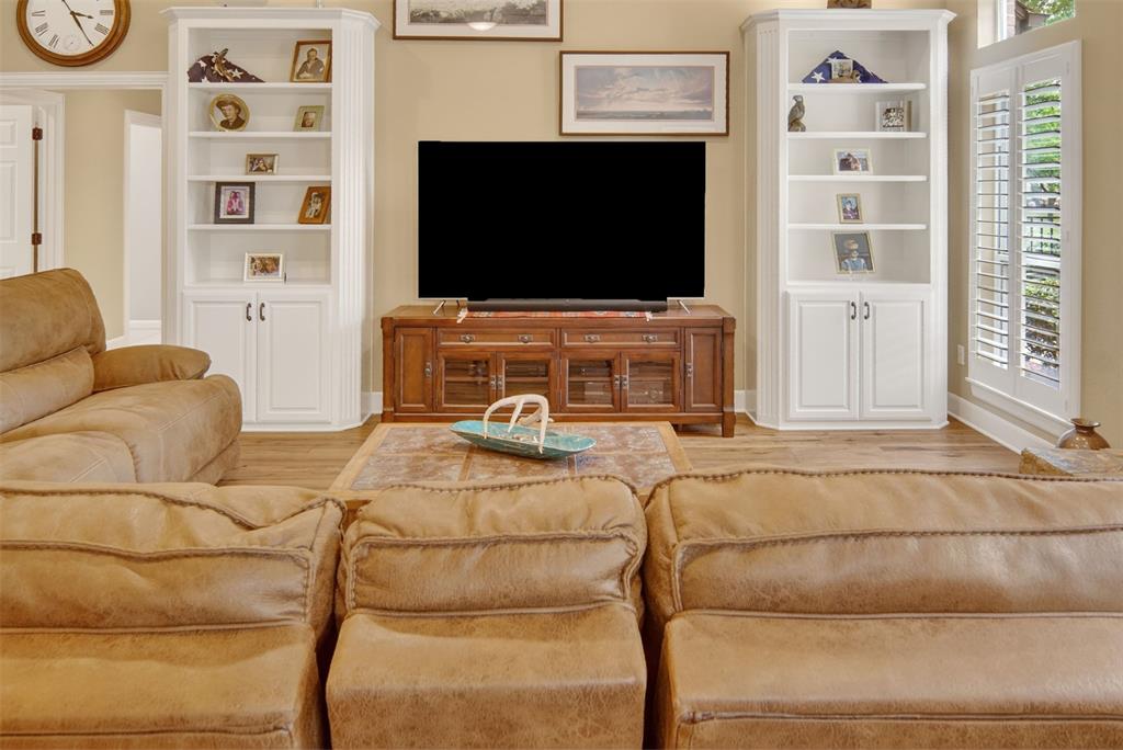 Additional view of family room with built ins, wood shutters, and wood flooring. Additional view of family room with built ins, wood shutters, and wood flooring.
