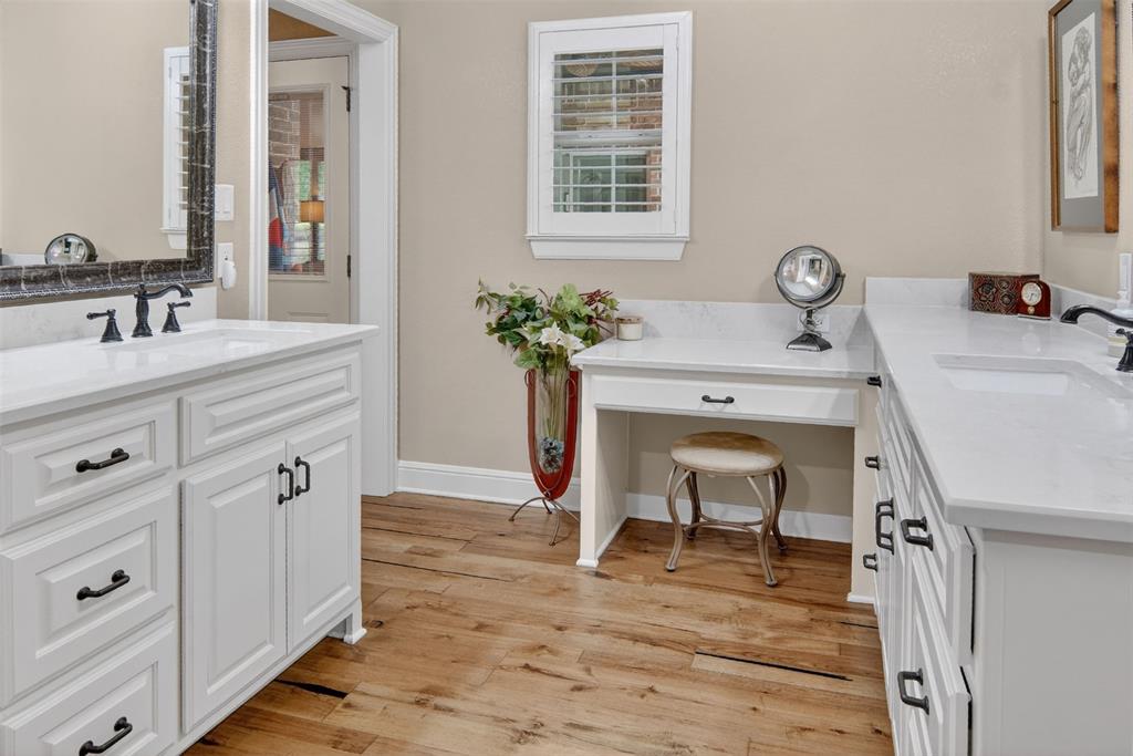 Recently updated primary bath with wood flooring and double vanities.