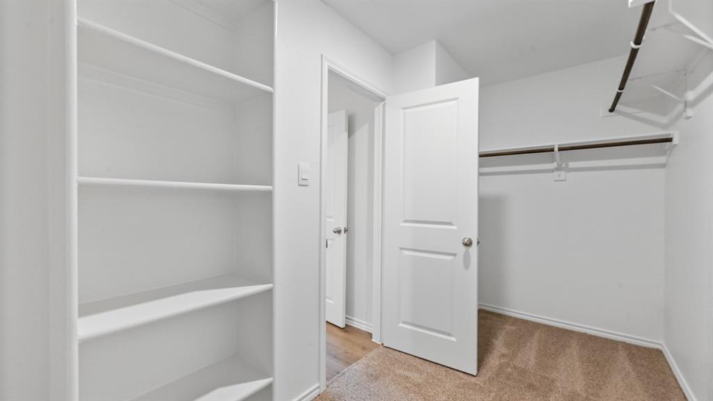 Built-in shelving and hanging rods offer versatile storage options within this space