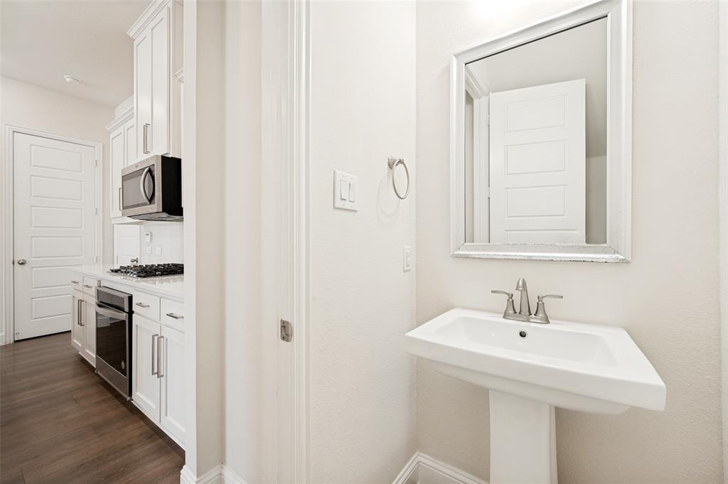Pedestal sink with a framed mirror and brushed nickel fixtures