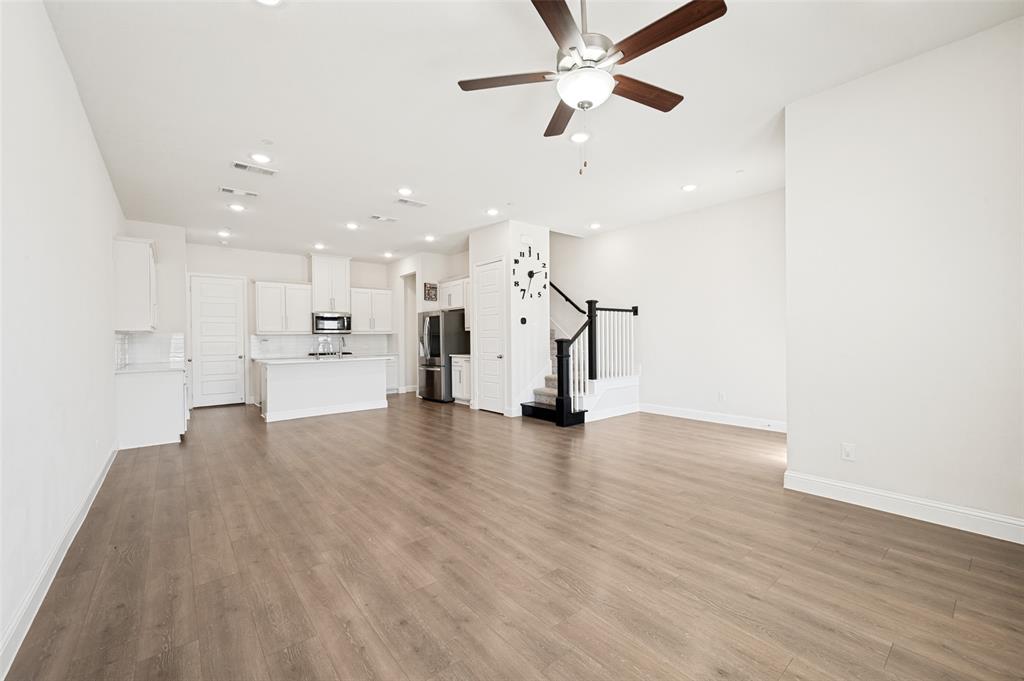 Open-concept living space featuring wood-finish flooring, recessed lighting, and a ceiling fan