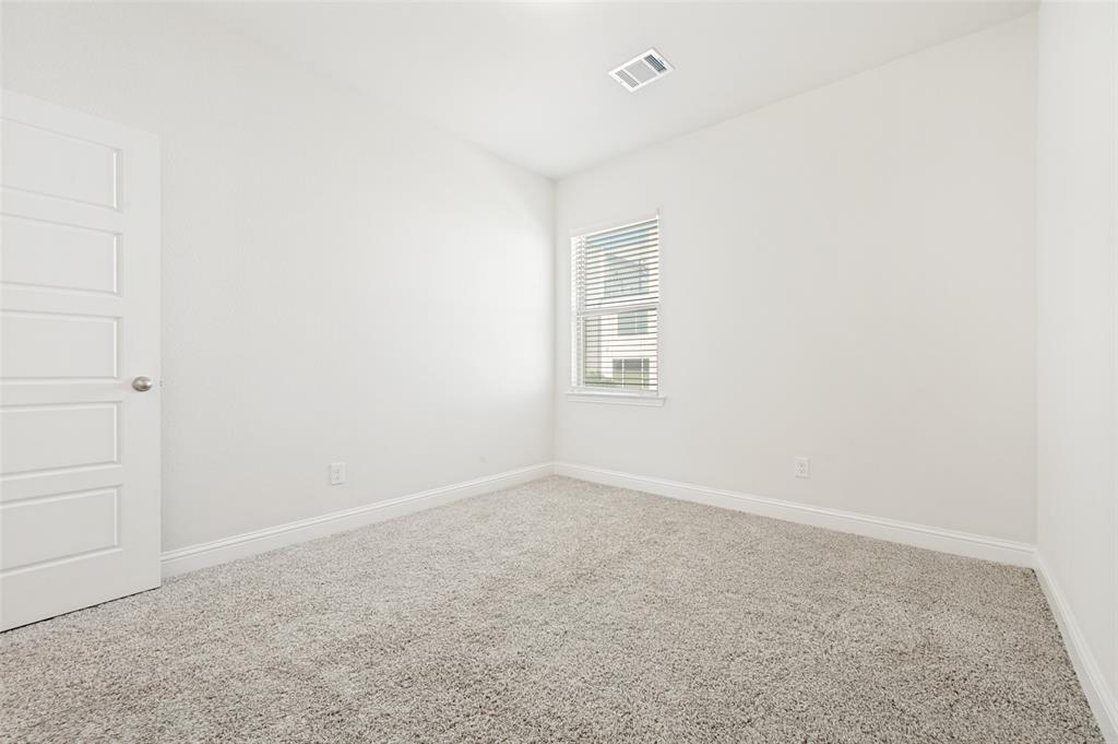 Bright room featuring light-colored carpeting, white baseboards, and a window with horizontal blinds