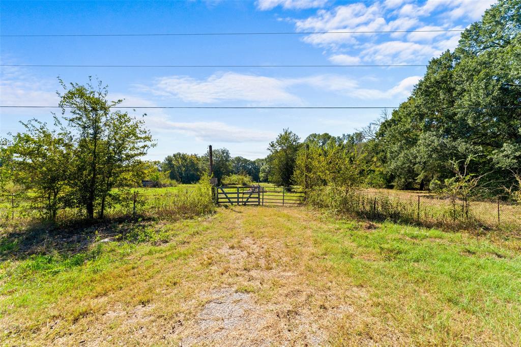 Gated entry to a expansive natural landscape with a gravel pathway