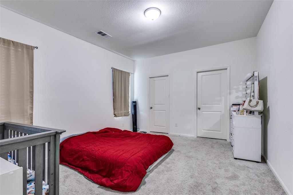 Carpeted room featuring two panel doors, two windows with blinds, and white painted walls