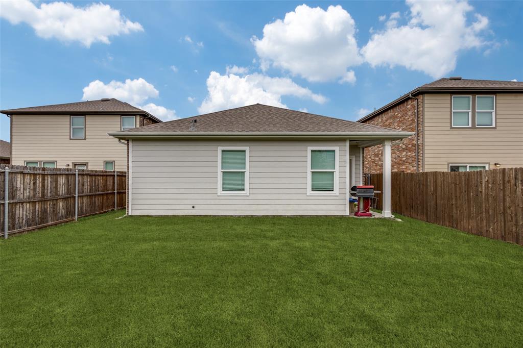 Expansive green lawn with a privacy fence