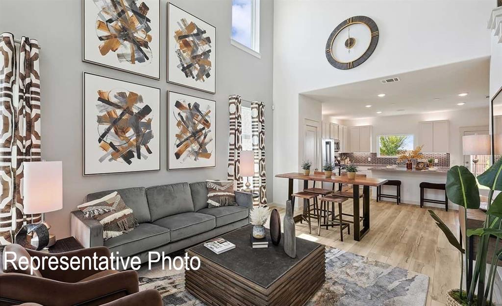 Open-concept living space featuring high ceilings, wood-finish flooring, and recessed lighting
