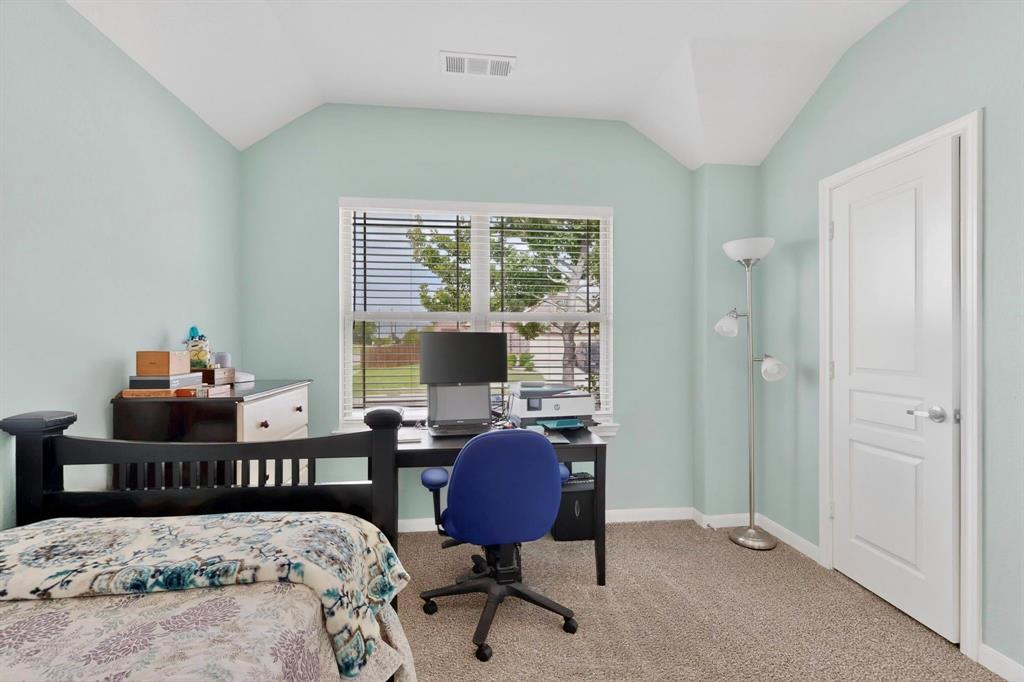 Carpeted room featuring a window with blinds, a vaulted ceiling, and a paneled interior door