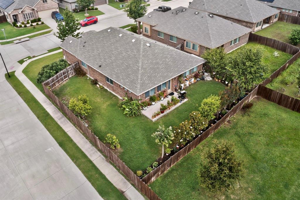 Expansive green lawn with established landscaping and a perimeter privacy fence
